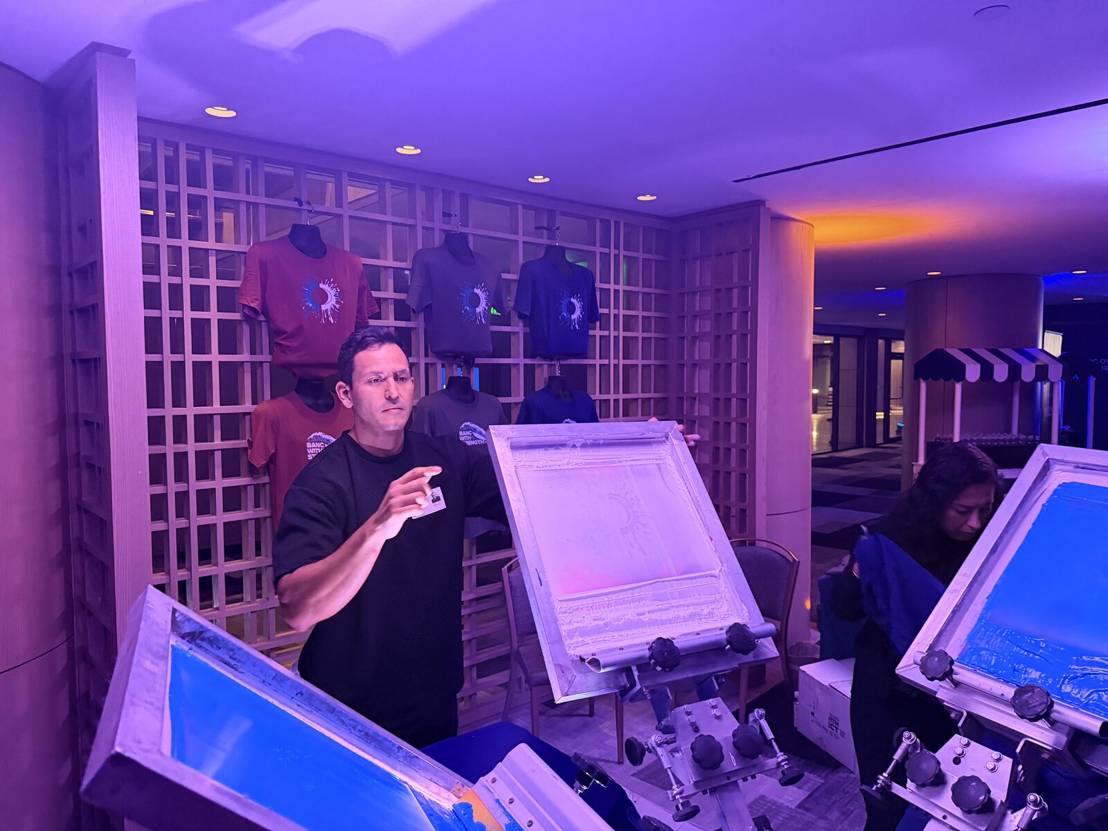 Presses lit up at a night-time live printing activation